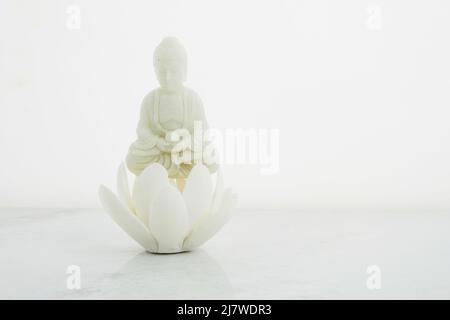 Vesak, Wesak, anniversaire de Bouddha. Statue de Bouddha avec lotus sur fond blanc. Rituel spa. Santé mentale et méditation. Banque D'Images