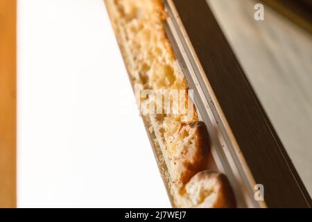 Ancienne mousse de montage sur le cadre d'une fenêtre en plastique démontée Banque D'Images