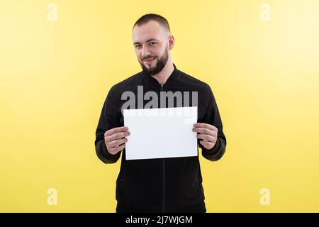 Homme d'affaires souriant avec support à barbe avec feuille blanche vide. Réalisation carrière richesse entreprise, placer le texte Banque D'Images