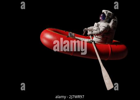 astronaute en canot rouge, isolé sur fond noir Banque D'Images