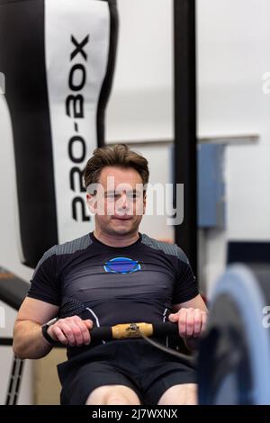 Ipswich Suffolk UK avril 03 2022: Un jeune homme en forme et en bonne santé utilisant une machine à ramer dans une petite salle de sport Banque D'Images