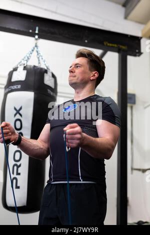 Ipswich Suffolk UK avril 03 2022: Un homme en forme et en bonne santé utilisant des bandes de résistance pour une séance d'entraînement du haut du corps Banque D'Images