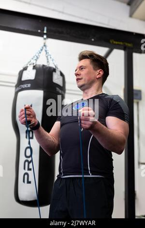 Ipswich Suffolk UK avril 03 2022: Un homme en forme et en bonne santé utilisant des bandes de résistance pour une séance d'entraînement du haut du corps Banque D'Images