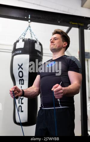 Ipswich Suffolk UK avril 03 2022: Un homme en forme et en bonne santé utilisant des bandes de résistance pour une séance d'entraînement du haut du corps Banque D'Images