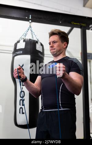 Ipswich Suffolk UK avril 03 2022: Un homme en forme et en bonne santé utilisant des bandes de résistance pour une séance d'entraînement du haut du corps Banque D'Images