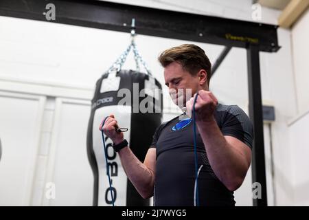 Ipswich Suffolk UK avril 03 2022: Un homme en forme et en bonne santé utilisant des bandes de résistance pour une séance d'entraînement du haut du corps Banque D'Images