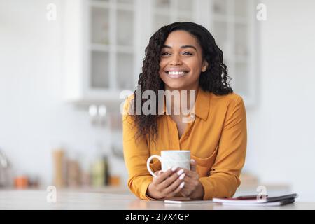 Jolie femme noire ayant la pause-café, regardant l'espace de copie Banque D'Images