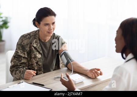 Portrait de la femme Soldier faire un bilan de santé avec la Black Doctor Lady Banque D'Images