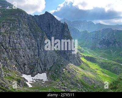 Vallée de montagne en été avec des rayons de soleil hypnotiques entre les nuages, dans les montagnes Bucegi, Roumanie Banque D'Images