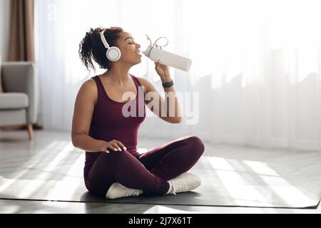 Femme noire athlétique qui boit de l'eau pendant l'exercice Banque D'Images