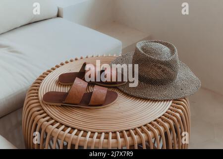 chaussures en cuir marron et chapeau de paille sur une table en bois Banque D'Images