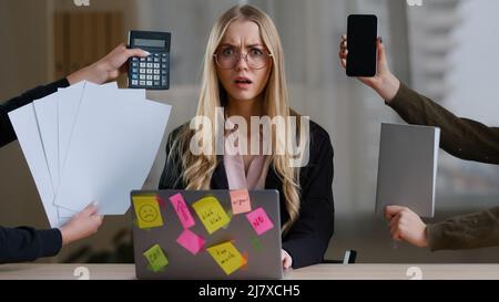 Multitâche femme d'affaires Manager dans le bureau assis à la table ont beaucoup de tâches travail sentir le stress trop travaillé épuisé des mains avec la calculatrice Banque D'Images