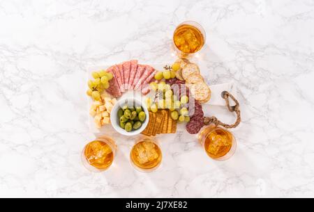 Pose à plat. Scotch sur les rochers en verre à whisky sur une surface en marbre blanc. Banque D'Images