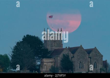 Oldbury-on-Severn, Gloucestershire, Royaume-Uni. 16th avril 2022. La quatrième pleine Lune de l'année, la Lune rose, s'élève au-dessus de l'église St Arilda à Oldbury-o Banque D'Images