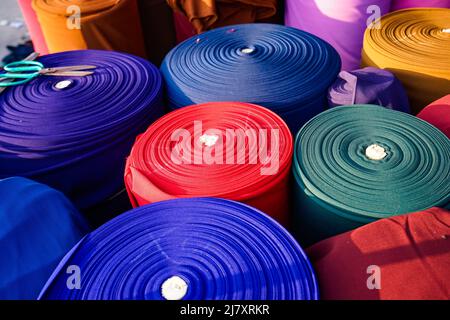 Rouleaux de tissus colorés sur un marché de tissus vietnamiens Banque D'Images