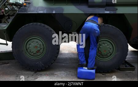 11 mai 2022, Saxe-Anhalt, Sülzetal: Un soldat d'entretien du bataillon logistique Bundeswehr 171 se tient sur un canister en plastique et répare le véhicule de transport blindé GTK Boxer. Au sud de Magdebourg, les logisticiens se préparent à soutenir la force de réaction rapide de l'OTAN. Ils font partie de l'exercice à grande échelle 'Wettiner Heide - Robuste Basis' avec actuellement un total de 7500 soldats. Photo: Ronny Hartmann/dpa Banque D'Images