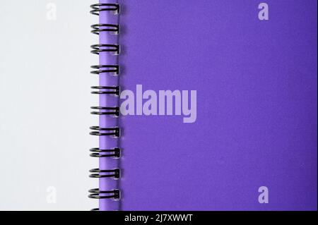Fait partie d'un cahier wirebond (ou à spirale) avec couvercle en plastique violet translucide sur fond blanc. Banque D'Images