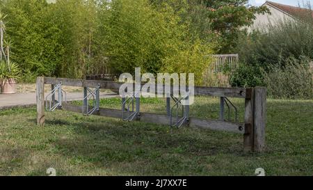 Support de vélo en bois sur herbe verte avec métal où les vélos peuvent être garés mais il est actuellement vide Banque D'Images