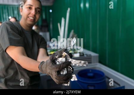Athènes, Grèce. 9th mai 2022. Un employé de la municipalité de l'île de Tilos détient des colis de médicaments à traiter au centre de recyclage de Tilos, en Grèce, le 9 mai 2022. Tilos, une petite île du sud-est de la mer Égée avec plus de 500 habitants, est la première île de Grèce à compter entièrement sur les énergies renouvelables pour répondre à ses besoins énergétiques. Après avoir été autosuffisant en énergie grâce à l'énergie éolienne et solaire, l'île, avec environ 80 pour cent de ses déchets maintenant recyclés, vise également à devenir une île « zéro déchet ». Crédit: Marios Lolos/Xinhua/Alamy Live News Banque D'Images
