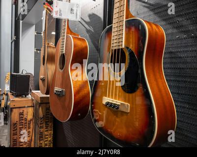 Lynnwood, WA USA - vers mai 2022: Concentration sélective sur les guitares basses électriques et acoustiques à vendre dans un magasin d'instruments de musique Guitar Center. Banque D'Images