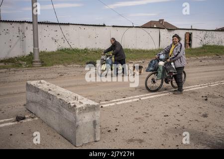 Kharkiv, Ukraine. 11th mai 2022. Deux personnes marchent leurs vélos près d'un mur en pots avec des éclats de shrapnel russes dans les parties nord de Kharkiv, Ukraine, mercredi, 11 mai 2022. Mardi, les États-Unis et leurs alliés européens ont accusé la Russie d'avoir lancé une cyber-attaque une heure avant l'invasion de l'Ukraine par le Kremlin en février, qui visait une société de communications américaine opérant à Kiev, causant des dégâts sur l'ensemble du continent. Photo de Ken Cedeno/UPI crédit: UPI/Alay Live News Banque D'Images