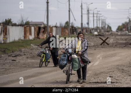 Kharkiv, Ukraine. 11th mai 2022. Deux personnes marchent leurs vélos sur une route parsemée de débris de pilonnage russe dans les parties nord de Kharkiv, Ukraine, le mercredi 11 mai 2022. Mardi, les États-Unis et leurs alliés européens ont accusé la Russie d'avoir lancé une cyber-attaque une heure avant l'invasion de l'Ukraine par le Kremlin en février, qui visait une société de communications américaine opérant à Kiev, causant des dégâts sur l'ensemble du continent. Photo de Ken Cedeno/UPI crédit: UPI/Alay Live News Banque D'Images