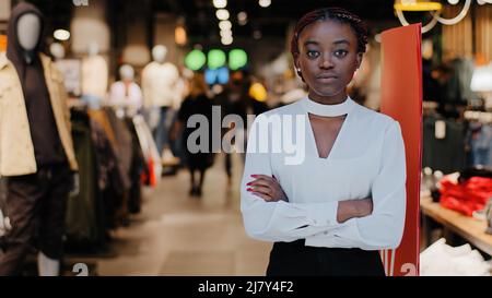 Femme femme petite entreprise africaine fille américaine femme vendeur de vêtements propriétaire de magasin se tient à l'entrée du centre commercial à la recherche Banque D'Images