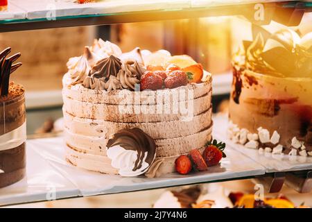 gâteau aux fraises, assortiment de pâtisseries délicieuses dans la boulangerie. Différents types de gâteaux sucrées dans pâtisserie vitrine en verre. Bon assortiment Banque D'Images