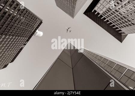 L'avion vole à travers le centre-ville européen dans le style photo monochrome . L'avion survole les gratte-ciel de Francfort. Paysage urbain impressionnant Banque D'Images