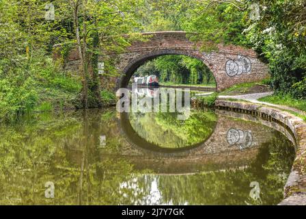 Un vieux pont se reflète dans les eaux parfaitement fixes du Canal de la Grande Union à Milton Keynes Banque D'Images