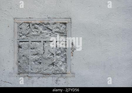 Fenêtre avec calandre, dans un ancien mur peint en blanc. Photo ou texture d'illustration Banque D'Images