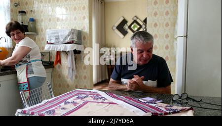 Joyeux senior commémorant les bonnes nouvelles sur le téléphone portable. Couple marié à la cuisine maison célébrant Banque D'Images