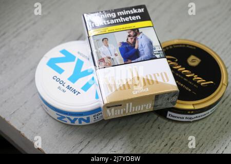 Le Conseil d'administration de Swedish Match AB a pris note des récentes spéculations et confirme que les discussions avec Philip Morris International Inc. Concernant une éventuelle offre publique de rachat de Swedish Match sont en cours. Il ne peut y avoir de certitude qu'une offre sera faite, ni quant aux termes de cette offre potentielle, écrit la société dans un communiqué de presse. Dans la photo: Marlboro Gold cigarette pack, de Philip Morris International Inc., et général original snus frpm Swedish Match AB. À gauche une boîte de menthe fraîche Zyn de Swedish Match AB. Banque D'Images