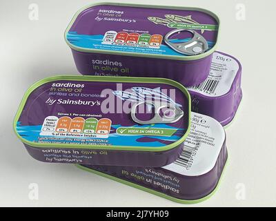 Shrinkflation : les sardines de Sainsbury sont maintenant vendues 90 grammes de boîtes, alors que les boîtes plus anciennes en contiennent 120 grammes. Deux boîtes plus anciennes à côté de deux nouvelles montrent le d Banque D'Images