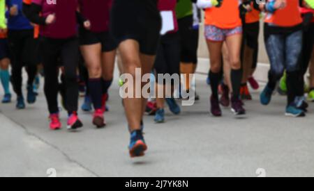 intentionnellement flou idéal pour l'arrière-plan de nombreuses jambes de personnes courant pendant la course à pied sur l'asphalte dans la ville Banque D'Images