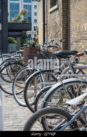 Une rangée de bicyclettes assorties garées à un porte-vélos à l'extérieur de l'école d'art du centre de Saint Martins à Coal Drops Yard. Londres, Angleterre, Royaume-Uni. Banque D'Images