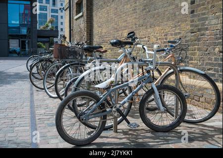 Une rangée de bicyclettes assorties garées à un porte-vélos à l'extérieur de l'école d'art du centre de Saint Martins à Coal Drops Yard. Londres, Angleterre, Royaume-Uni. Banque D'Images