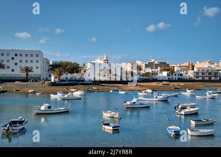 Bateaux de pêche amarrés dans la baie de l'océan Atlantique et vue sur la ville d'Arrecife. Charco de san Gines. Île de Lanzarote. Canaries, Espagne. Destinations de voyage, Banque D'Images