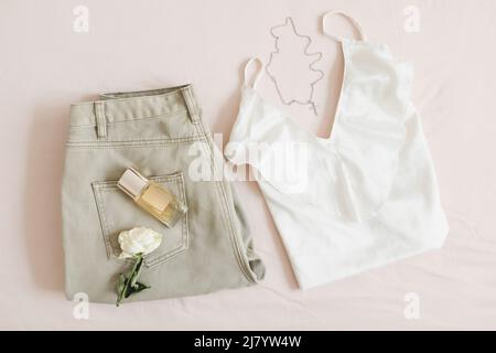 Vue de dessus de la tenue de jour décontractée pour femme, des vêtements et accessoires élégants sur fond beige. Pose à plat Banque D'Images