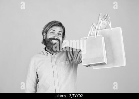 Bon achat. Surprise d'anniversaire à la fête. Homme avec forfait. Préparez-vous pour les vacances. Meilleure offre de vente. Joyeux homme barbu avec pack de cadeau. Gai Banque D'Images