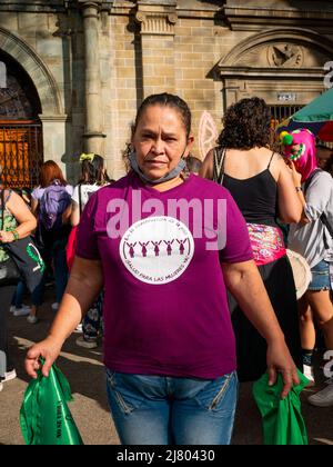 Medellin, Antioquia, Colombie - Mars 8 2022: Femme vêtue de violet montre son T-shirt avec le message "dans la construction de la paix, la santé pour tous Banque D'Images