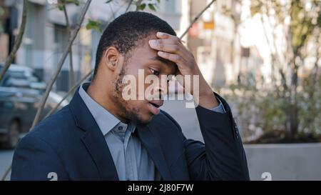 Stress épuisé jeune employé de compagnie de race mixte ayant des sentiments de tête douloureux en raison de travail excessif d'ordinateur ou de mode de vie de travail sédentaire. Noir fatigué Banque D'Images