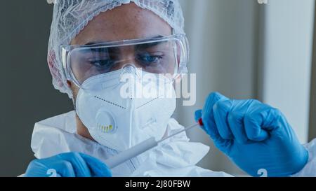 Portrait arabe hispanique homme médecin travailleur médical en costume de protection PPE a effectué un écouvillon de congestion de la personne non reconnaissable pour tester le coronavirus Banque D'Images