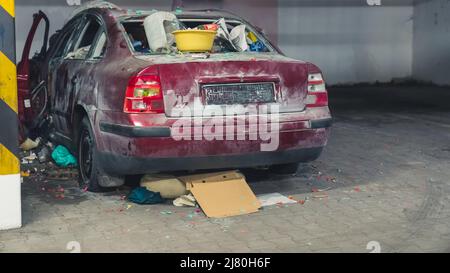 partie arrière d'une voiture détruite avec des déchets dans le stationnement souterrain plein coup. Photo de haute qualité Banque D'Images