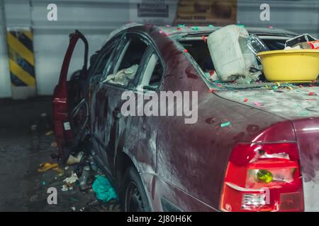 voiture dévastée pleine de déchets dans le parking souterrain. Photo de haute qualité Banque D'Images