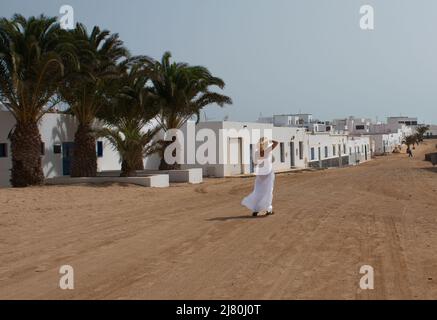 Femme marchant sur la route dans le village de pêcheurs, la Graciossa, Las Palmas, îles Canaries, Espagne Banque D'Images