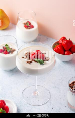 yaourt avec framboises et granola dans un verre et des verres sur un Banque D'Images