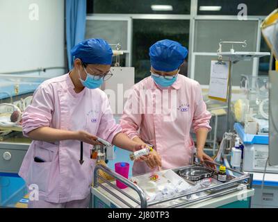 TAIZHOU, CHINE - le 12 MAI 2022 - Une infirmière vérifie les renseignements d'un nouveau-né avant de prendre du sang à l'unité de soins intensifs néonatals (USIN) de Taizhou Peo Banque D'Images