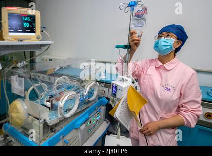 TAIZHOU, CHINE - 12 MAI 2022 - Une infirmière regarde le remplacement des liquides à l'unité néonatale de soins intensifs (USIN) de l'hôpital populaire de Taizhou à Taizhou, Banque D'Images