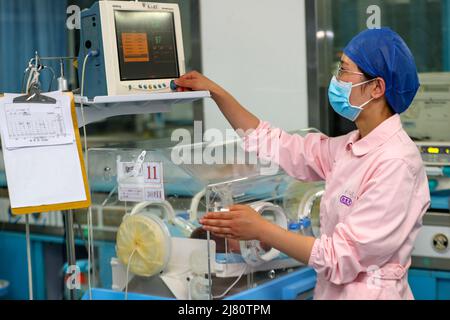 TAIZHOU, CHINE - 12 MAI 2022 - Une infirmière fixe les paramètres de surveillance à l'unité néonatale de soins intensifs (USIN) de l'hôpital populaire de Taizhou à Taizhou, Banque D'Images